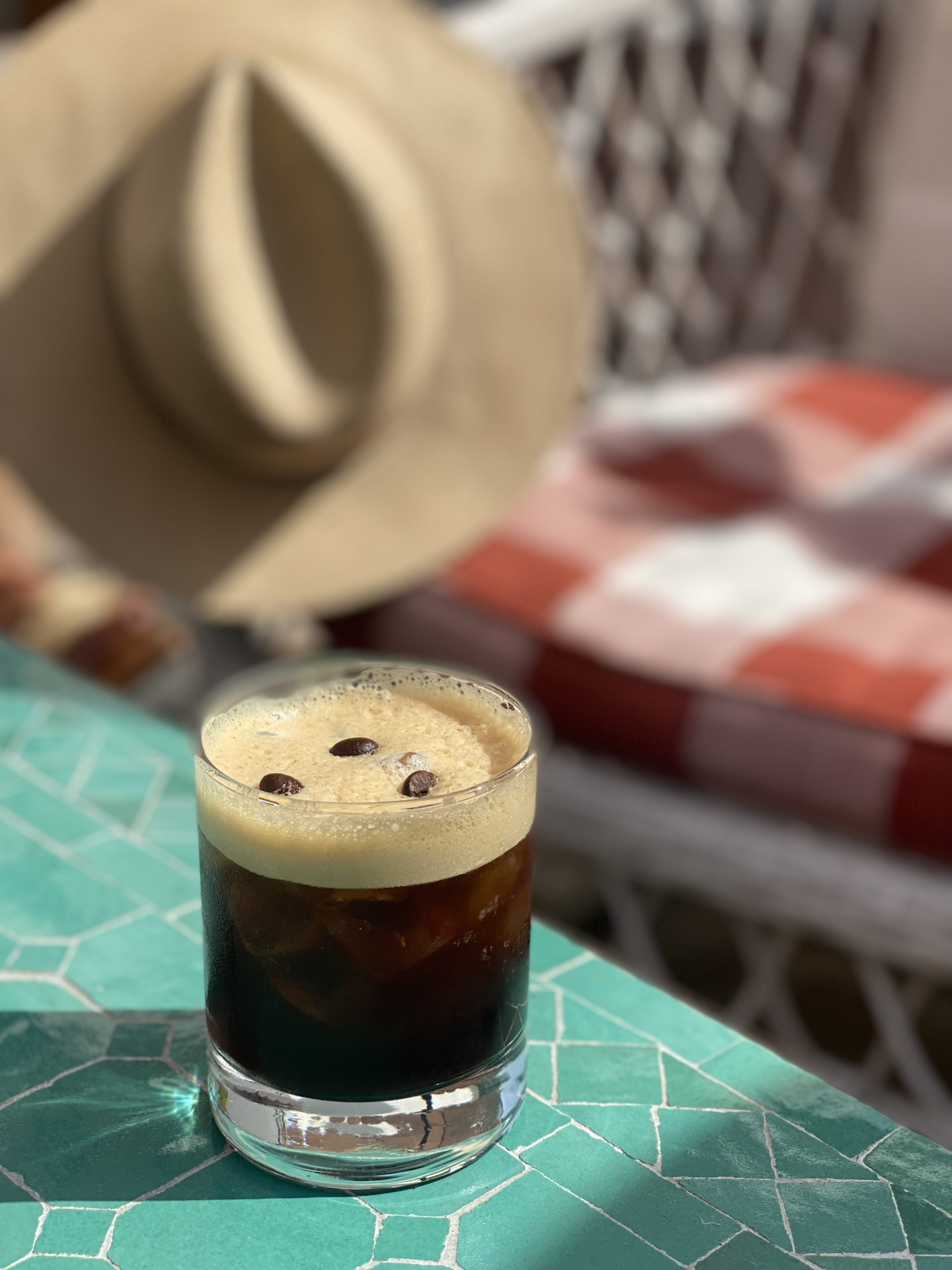 A 21Seeds Espresso Martini cocktail garnished with three beans, sitting on a table